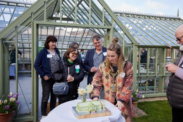 The Mayor of H&F, Cllr Emma Apthorp, cuts a cake to officially open the new glasshouse