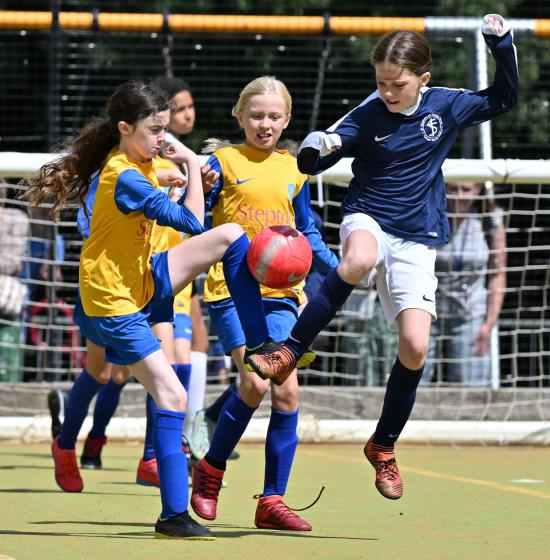 Action on the pitch from Larmenier & Sacred Heart (in light blue/yellow) and St Stephen's (in dark blue)